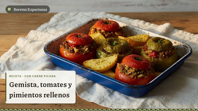 Tomates y pimientos rellenos de arroz y carne picada en una bandeja, imagen de la receta de Gemista